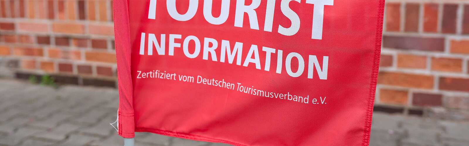 Teilansicht rote Fahne mit Schrift "Touristinfo"