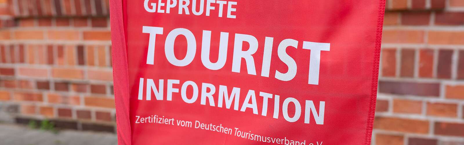 Teilansicht rote Fahne mit Schrift "Touristinfo"