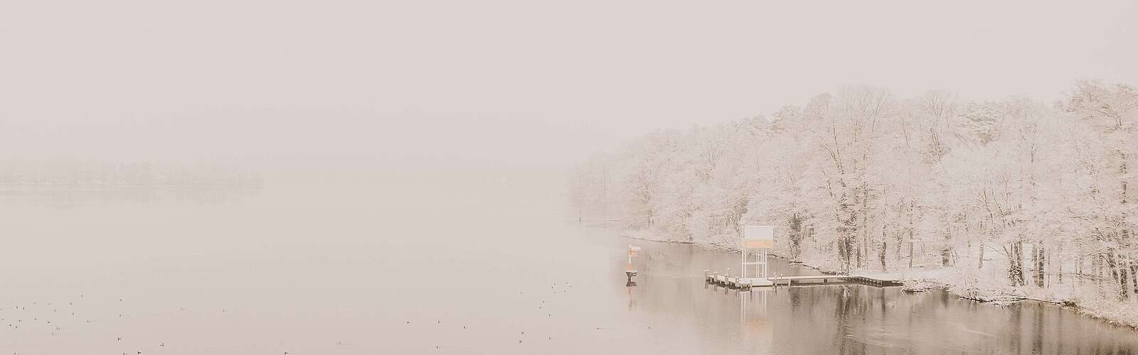 <p>Dahme im Nebel mit Steg am Ufer aus der Vogelperspektive</p>